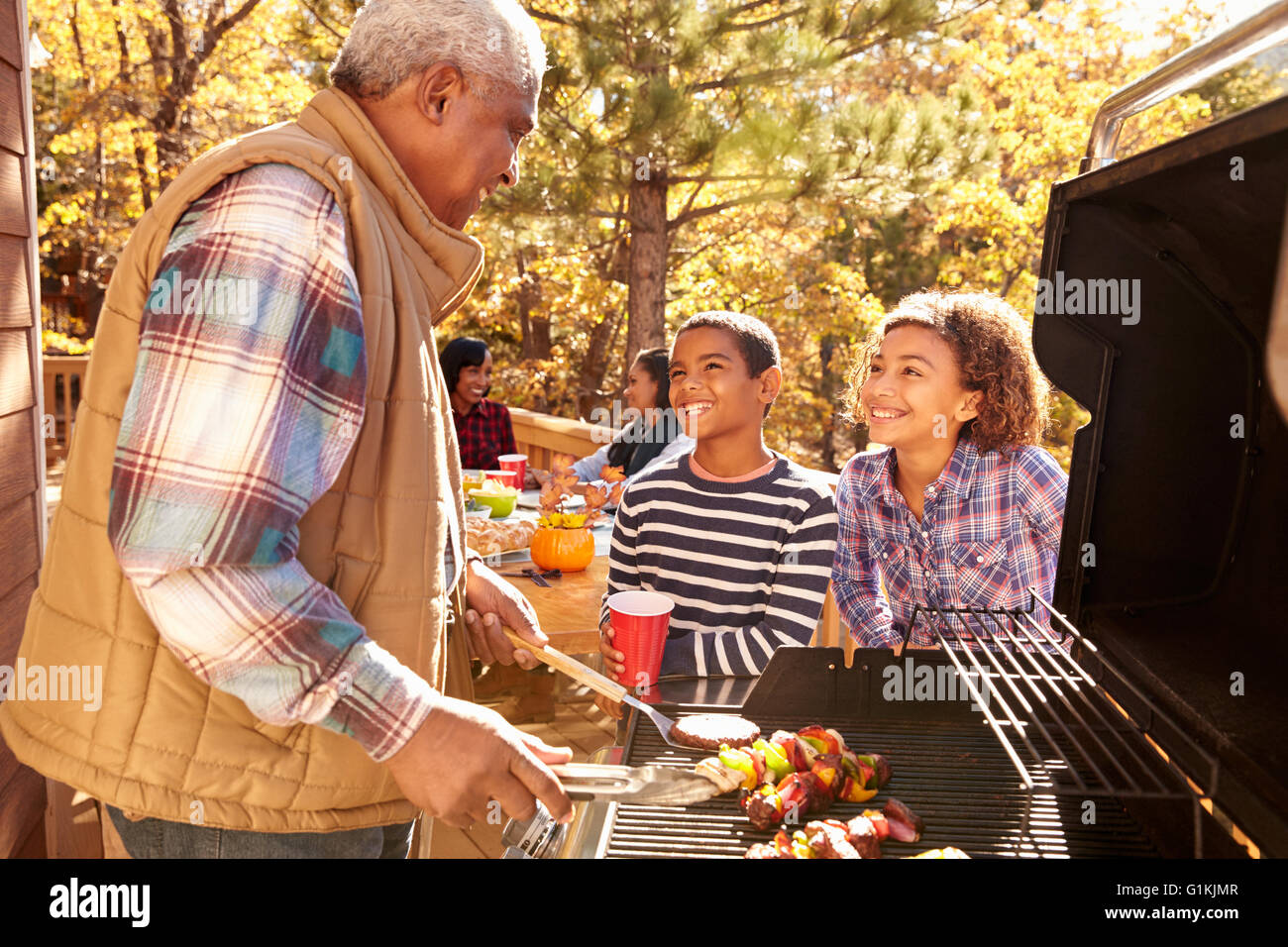 Grandparents With Children Enjoying Outdoor Barbecue Stock Photo