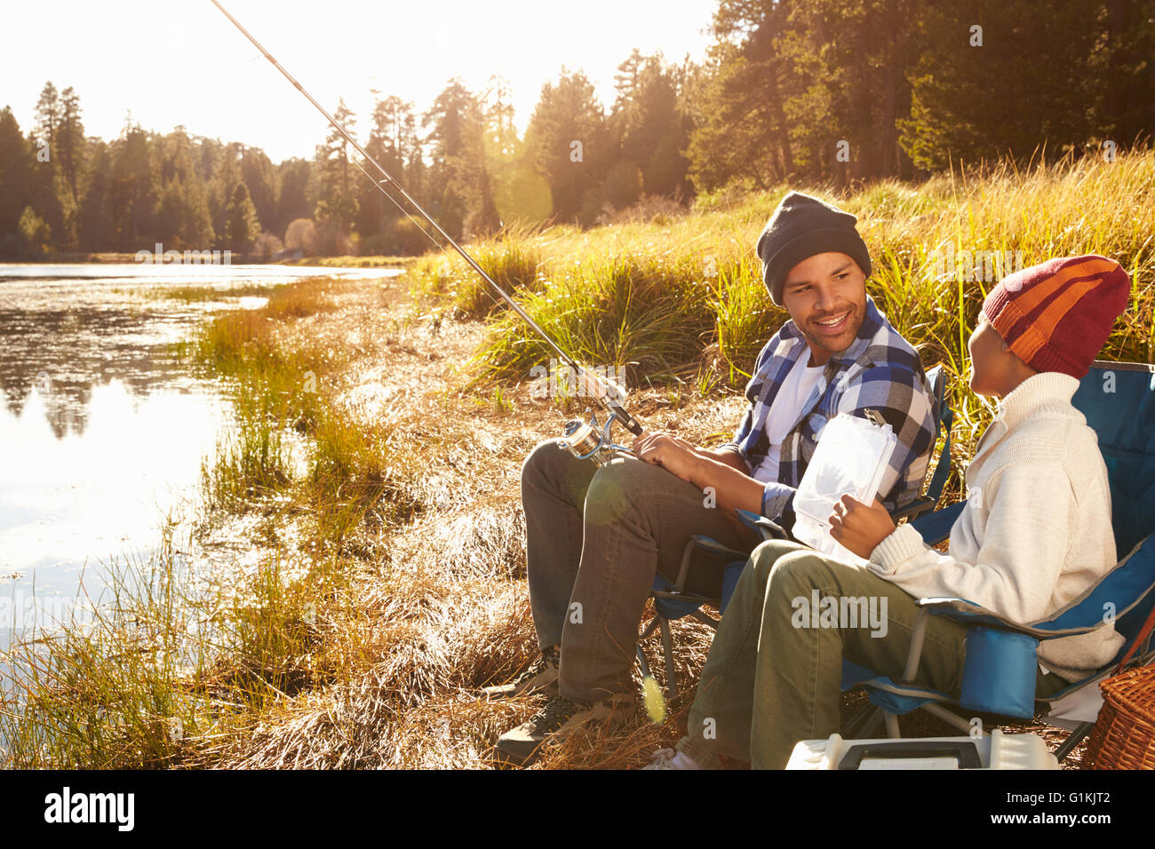Father Teaching Son To Fish By Lake Stock Photo - Alamy