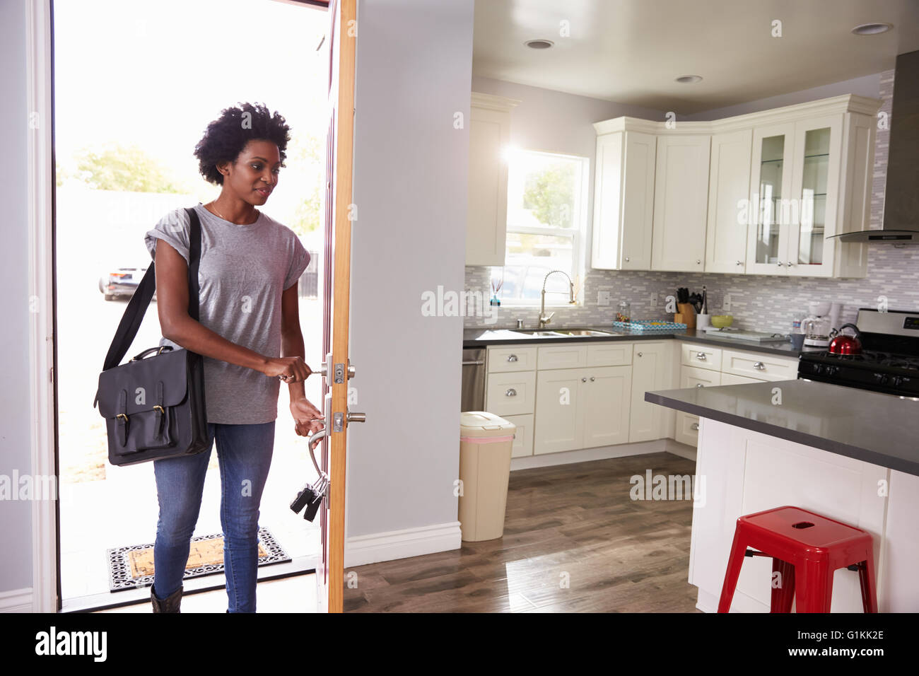 Woman Coming Home From Work And Opening Door Of Apartment Stock Photo