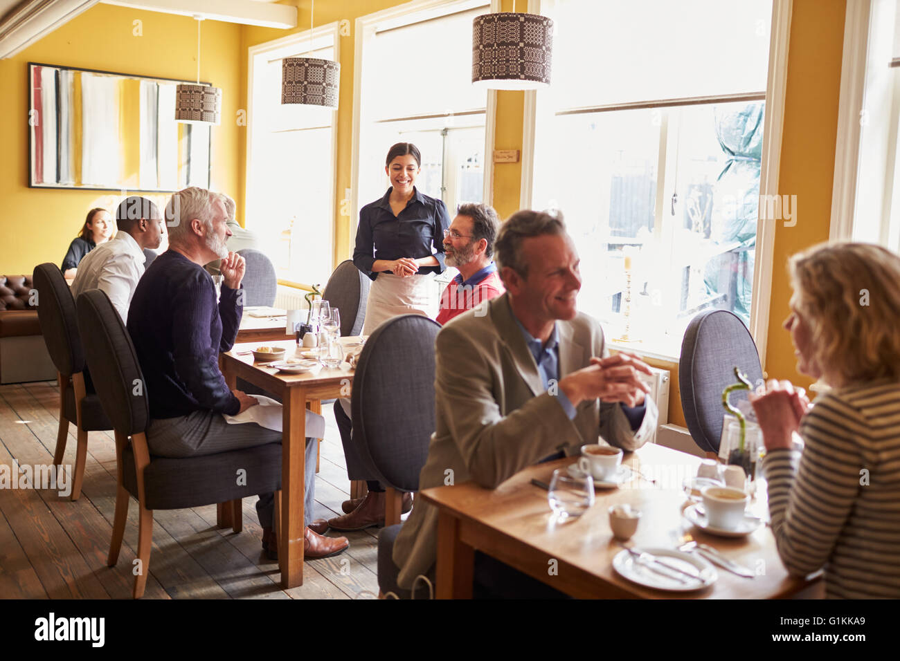 Overview of customers and a waitress in restaurant interior Stock Photo
