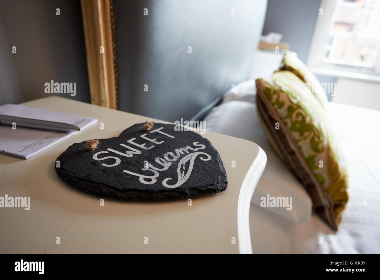 Sweet Dreams Printed On Slate Heart Next To Hotel Bedroom Stock Photo