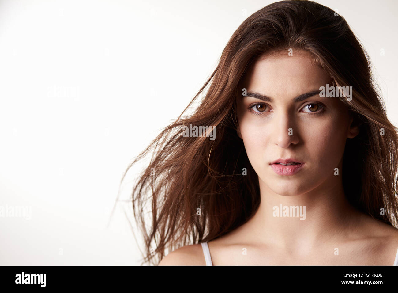 Dark haired girl in late teens with serious expression Stock Photo