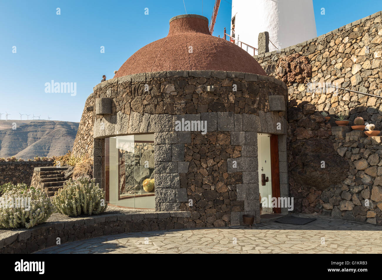 Entrance to the stairwell at the Lanzarote Cactus Garden, overlooked by a windmill. Designed by César Manrique. Stock Photo