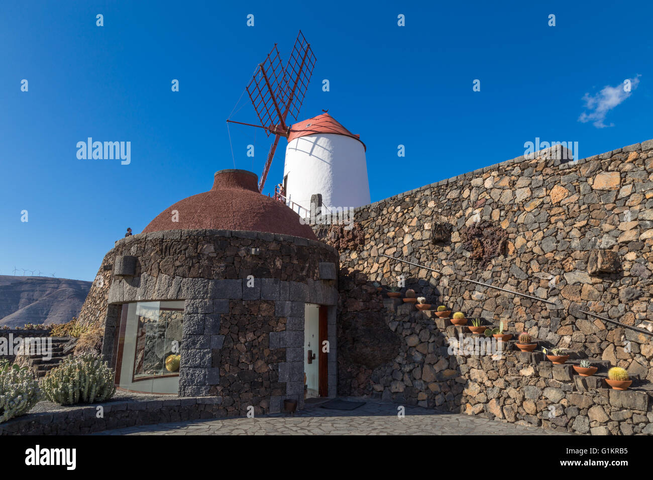 Entrance to the stairwell at the Lanzarote Cactus Garden, overlooked by a windmill. Designed by César Manrique. Stock Photo