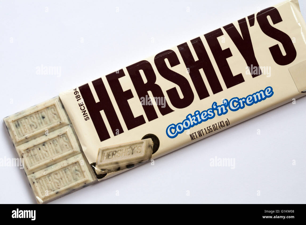 Bar of Hershey's Cookies 'n' Creme bar white chocolate flavoured candy with cookie pieces open to show contents set on white background Stock Photo