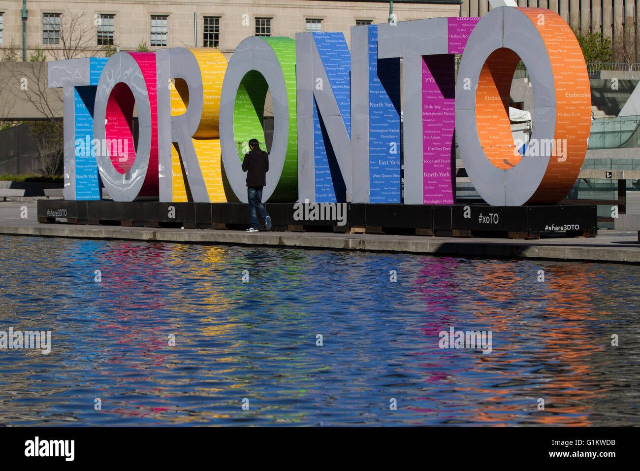 A man walks by the Toronto 3d sign in Nathan Phillips Square Toronto Ont., on May 8, 2016. Stock Photo