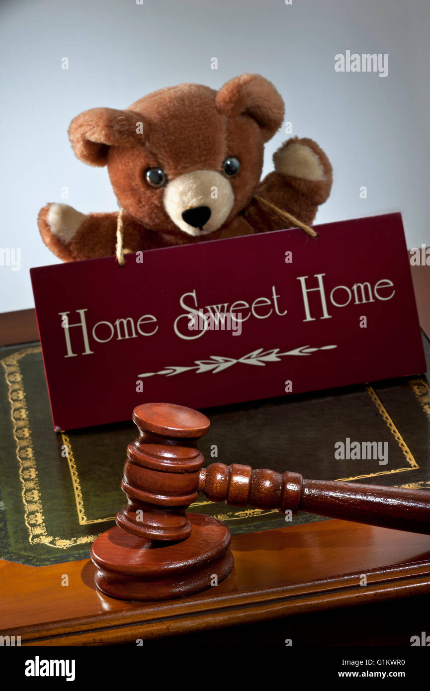 House sale by auction/law concept, auctioneers hammer & 'Home Sweet Home' sign with child's appealing teddy bear in support Stock Photo