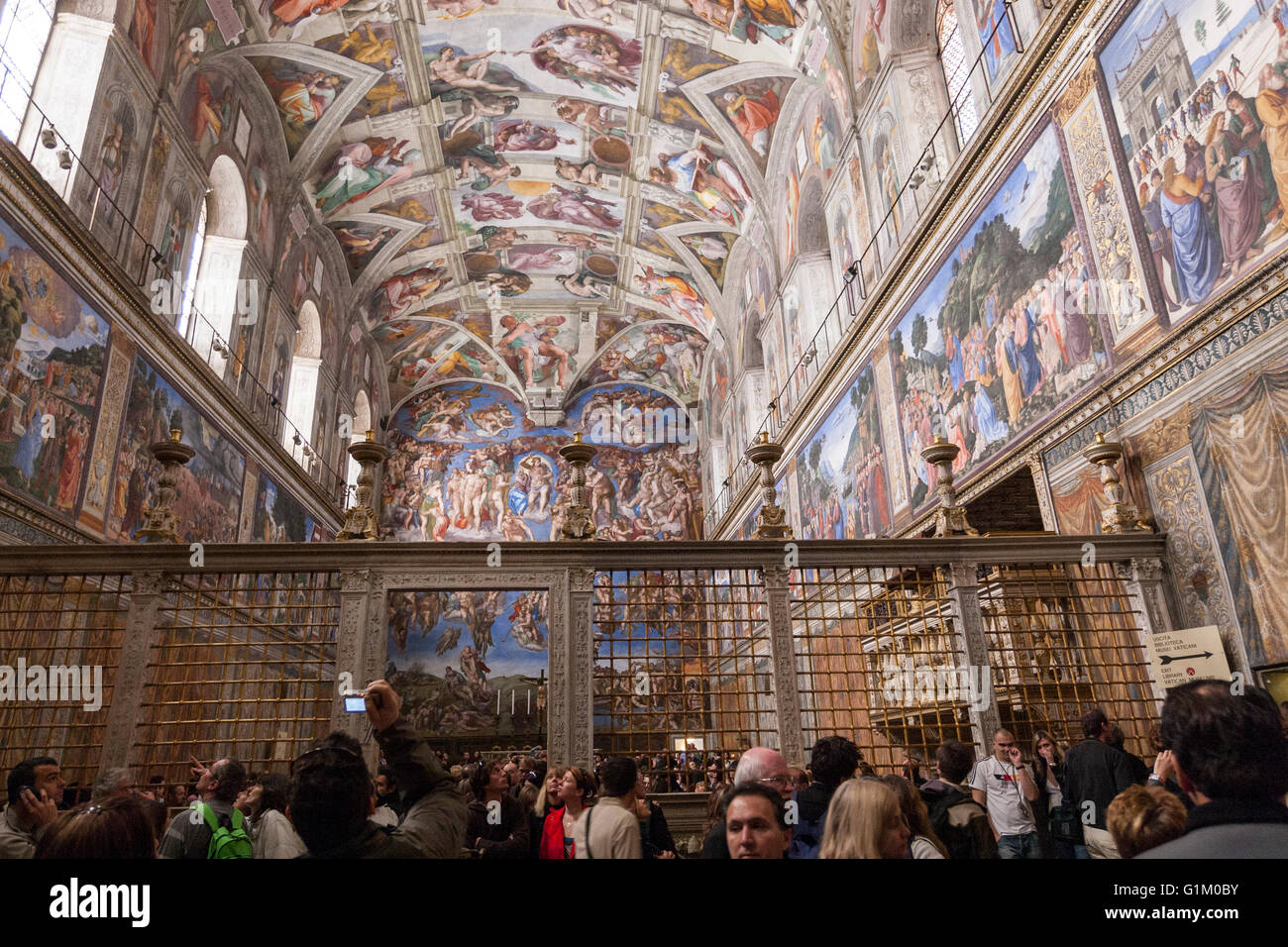 Overcrowd with tourist in the Sistine Chapel, ceiling painted by Michelangelo, from the entrance wall Stock Photo