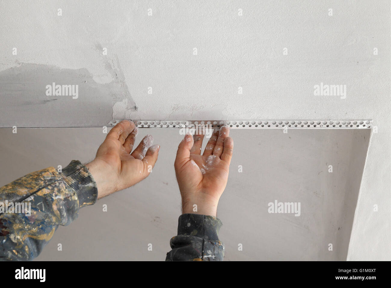 Worker Install Corner Protecting Batten To Ceiling And Wall