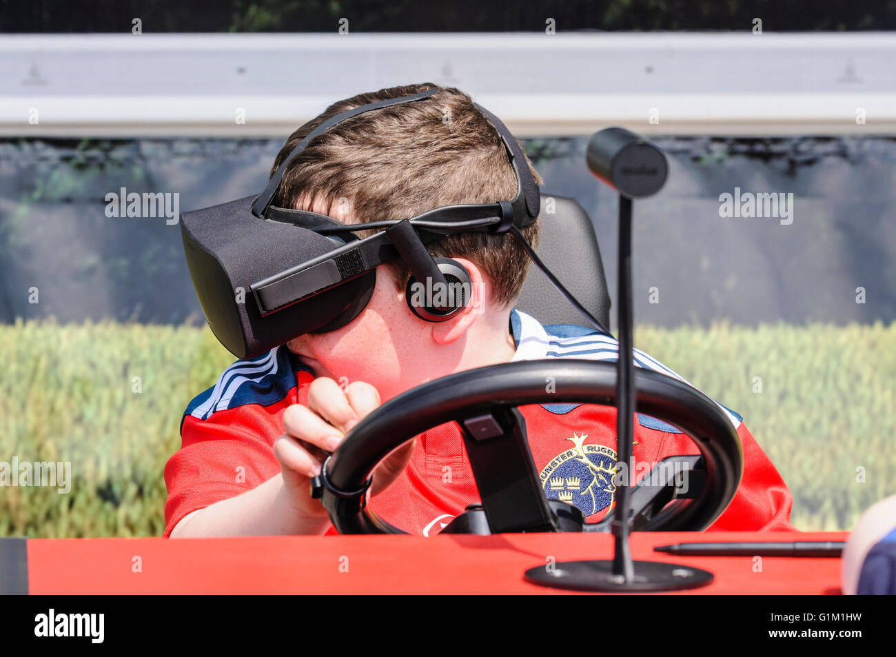 A boy uses an Oculus Rift on a tractor driving simulator Stock Photo