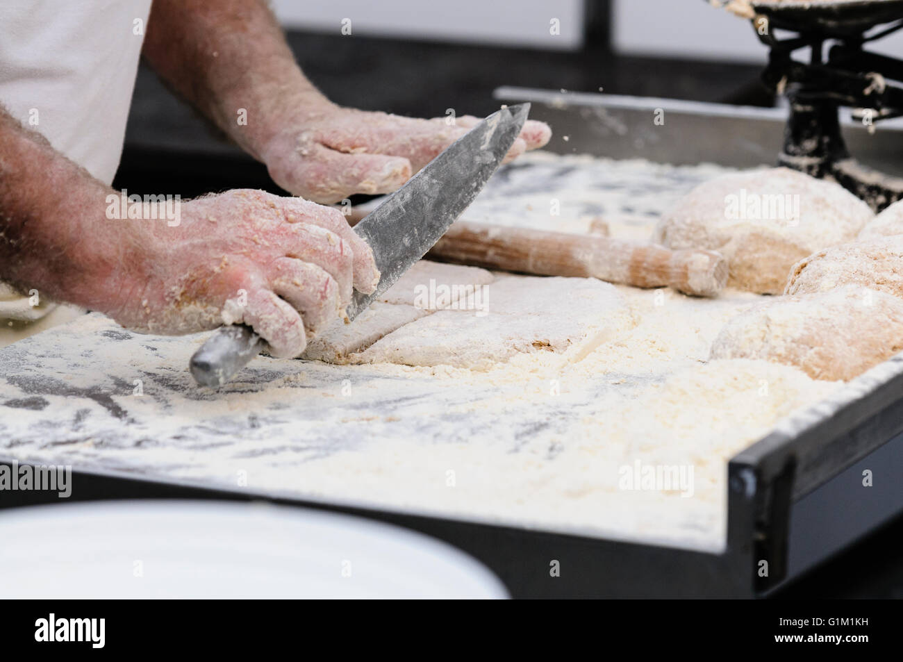 A man makes Irish traditional soda bread farls, common in most of Ireland, but particularly in Northern Ireland. Stock Photo