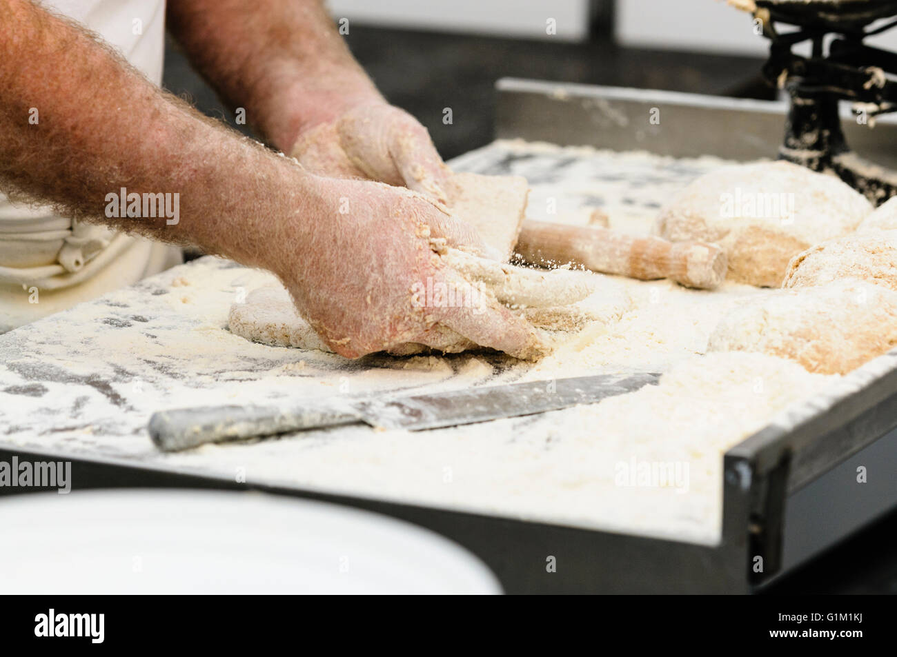 A man makes Irish traditional soda bread farls, common in most of Ireland, but particularly in Northern Ireland. Stock Photo