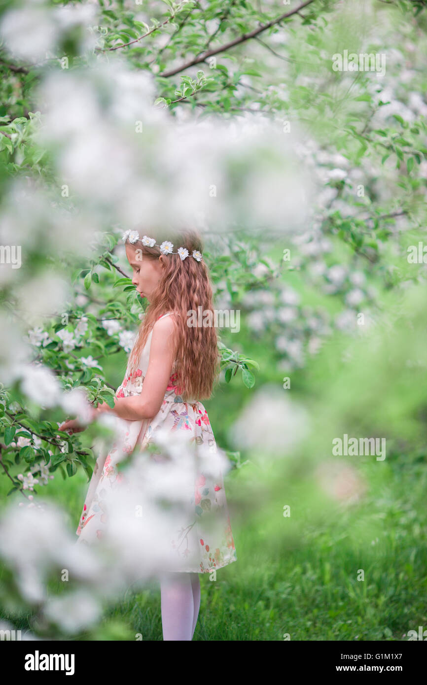 Little cute girl in blooming cherry garden outdoors Stock Photo - Alamy