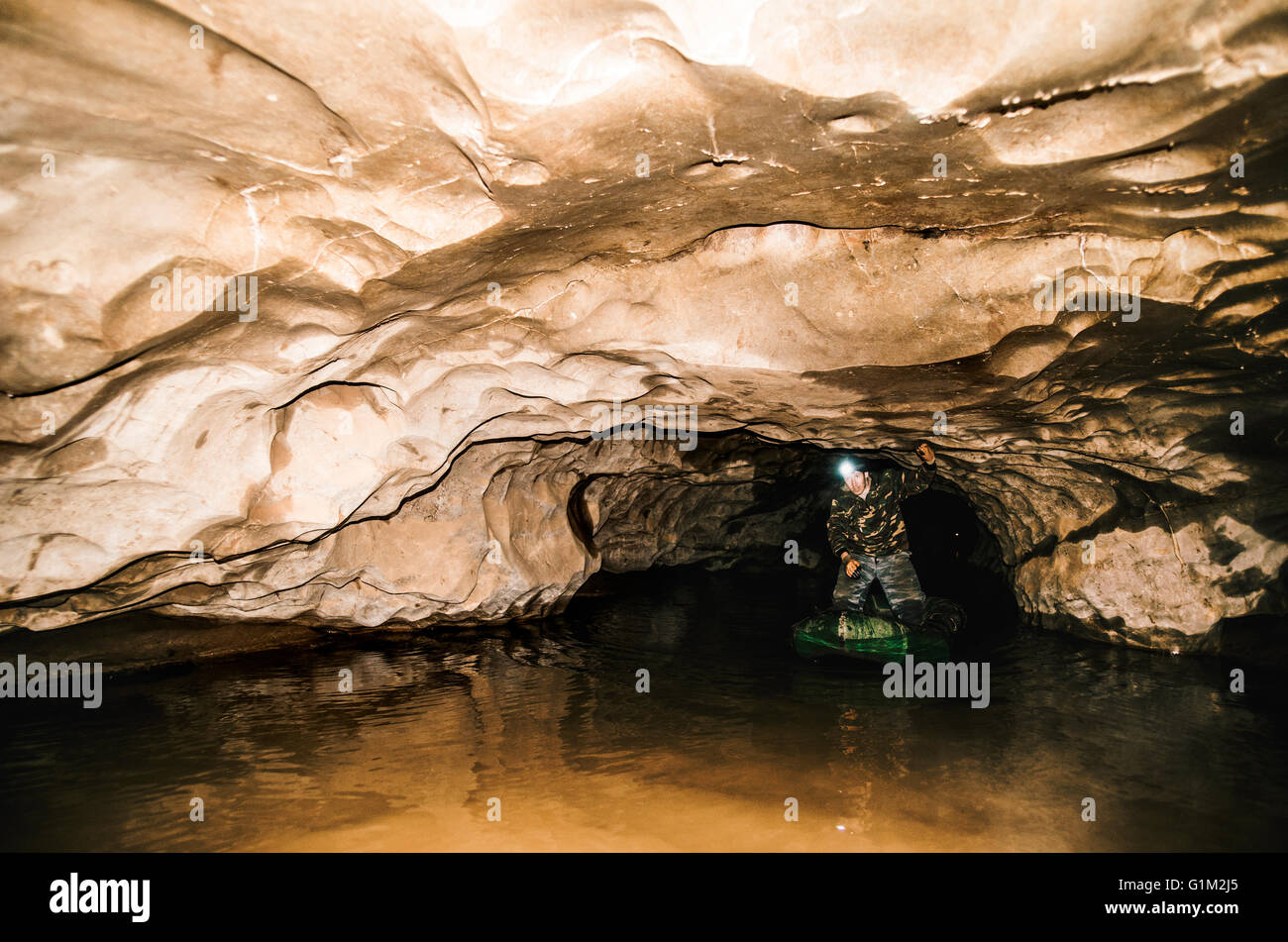 Caucasian hiker standing in cave Stock Photo