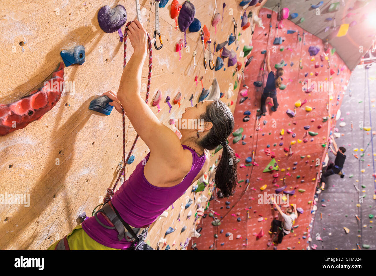 Climbers scaling rock wall Stock Photo