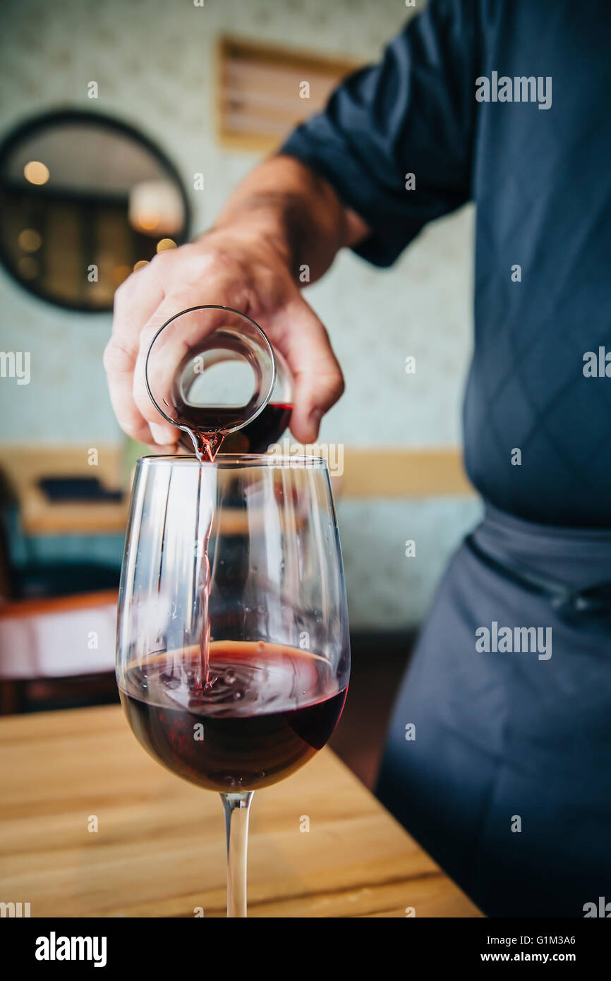 Caucasian waiter pouring wine in cafe Stock Photo Alamy