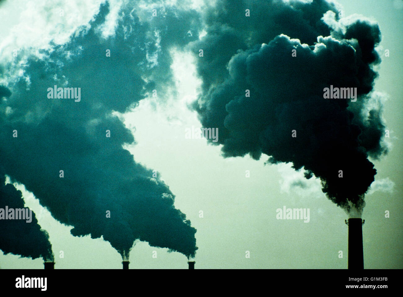 Smoke billowing from industrial smoke stacks Stock Photo