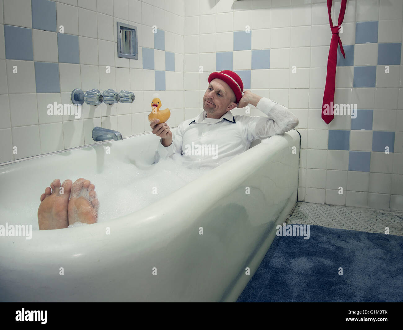 Caucasian businessman wearing clothing in bathtub Stock Photo