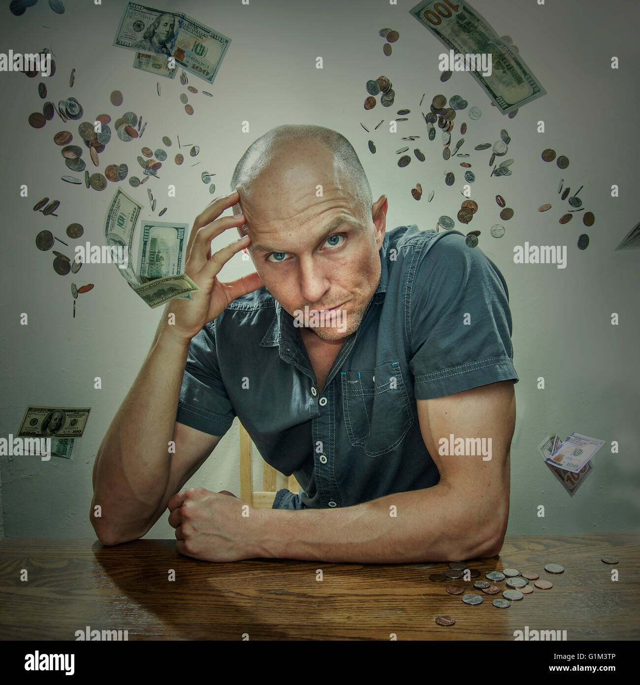 Caucasian man sitting in falling money Stock Photo