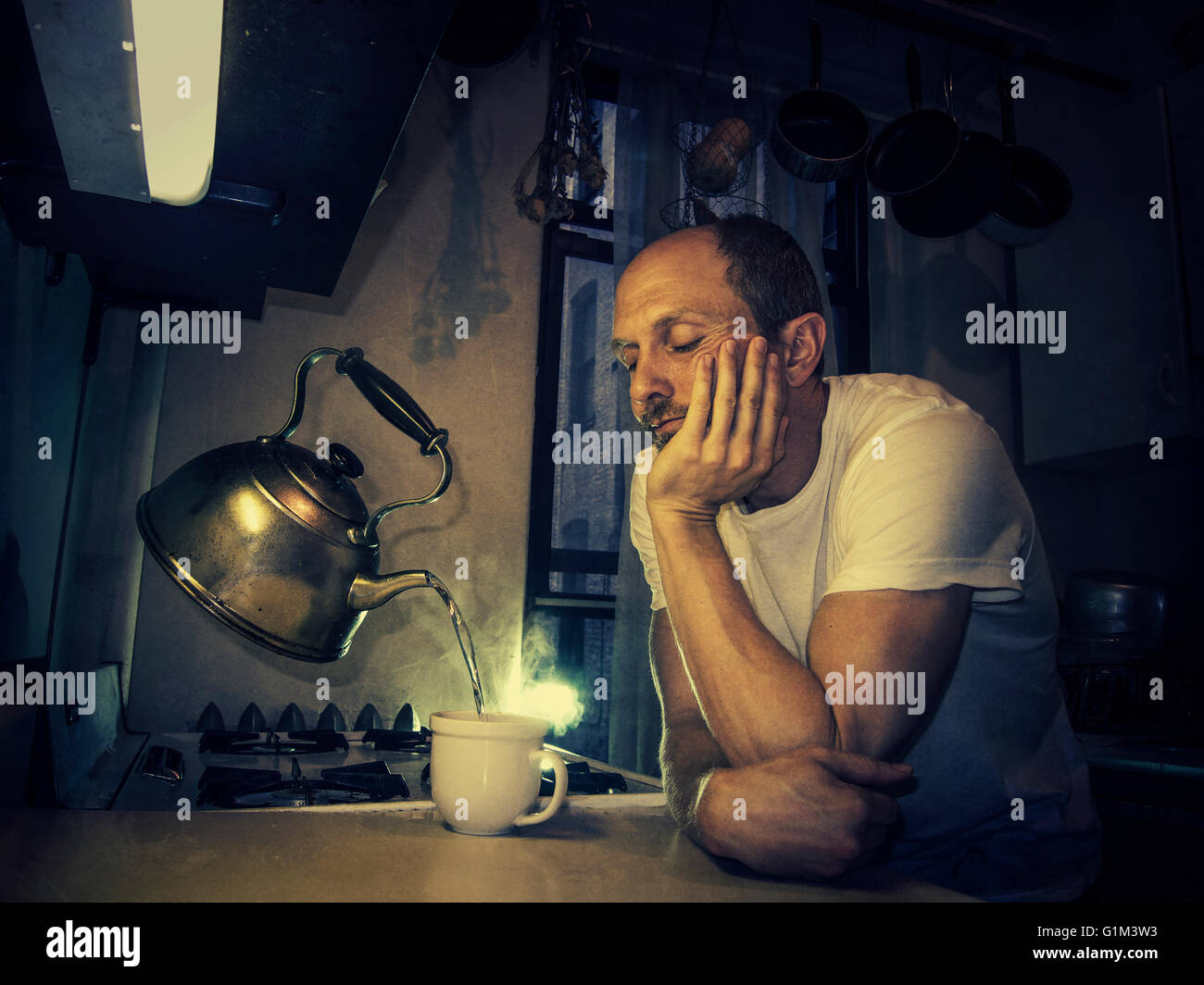 Caucasian man pouring cup from levitating tea kettle Stock Photo