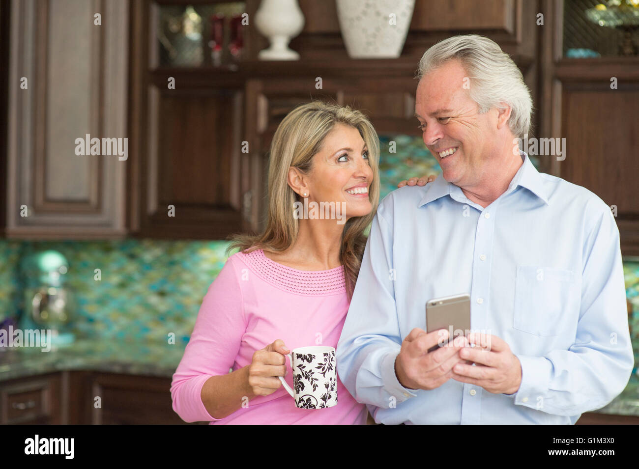 Caucasian couple smiling in kitchen Stock Photo
