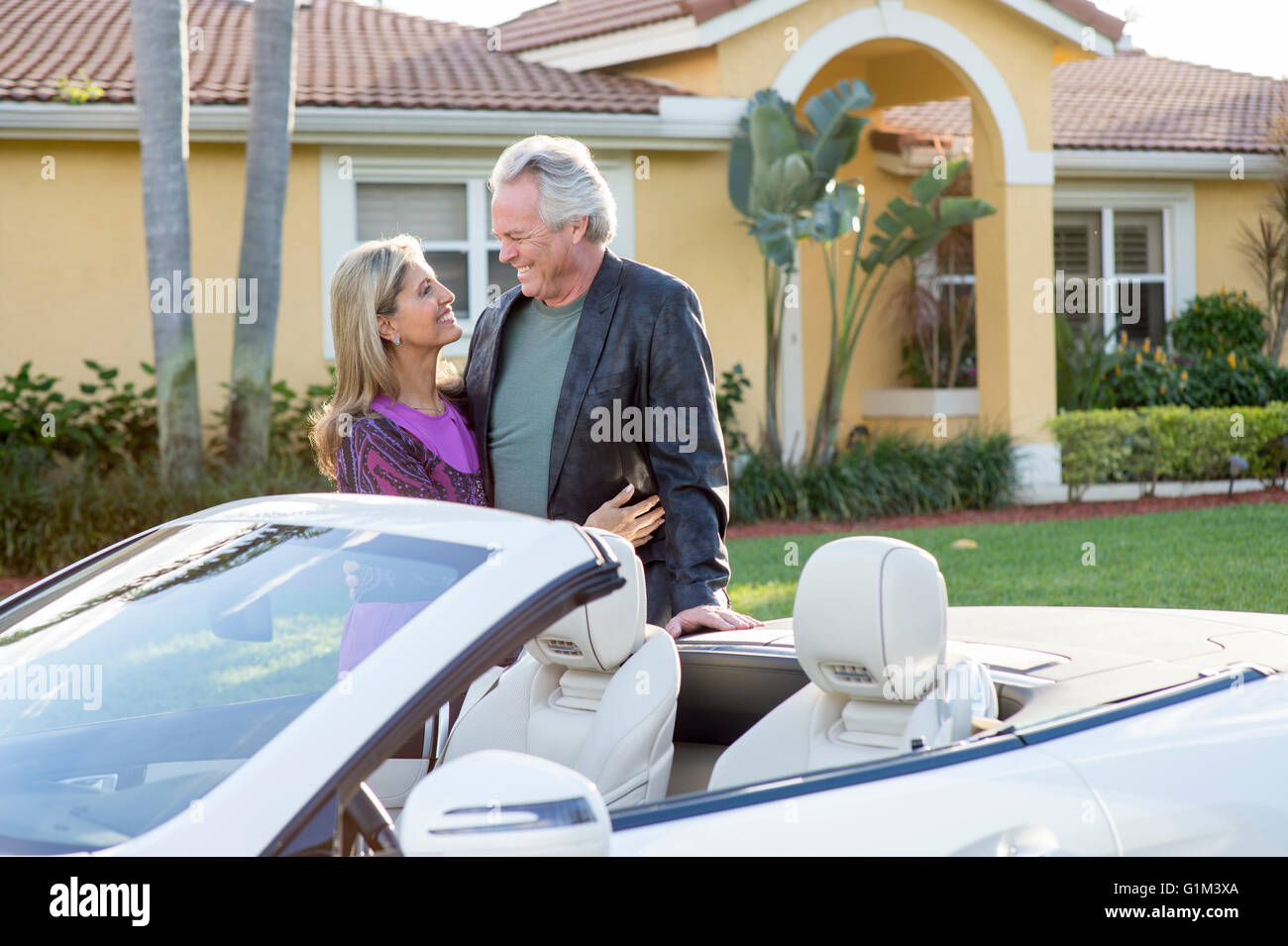 Caucasian couple smiling near convertible Stock Photo
