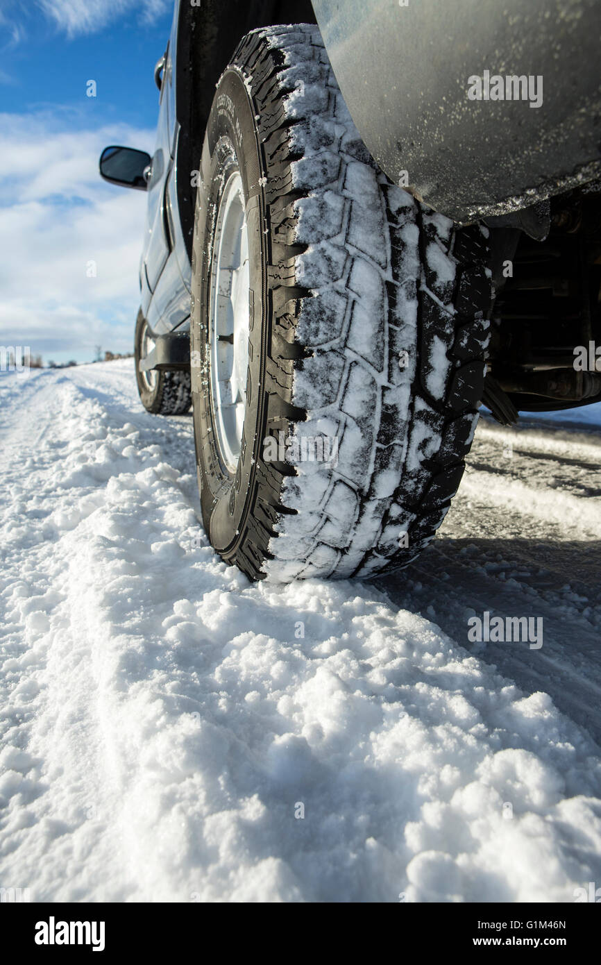 Close up of car tires driving in snow Stock Photo