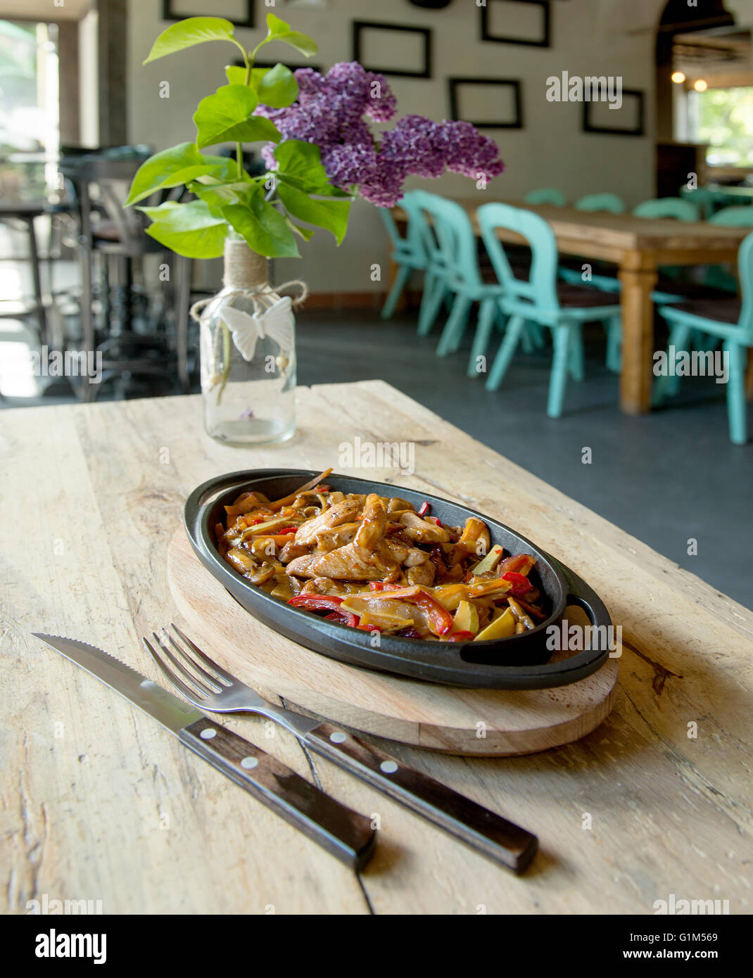 delicious spicy chicken pan on wooden table in a pub Stock Photo