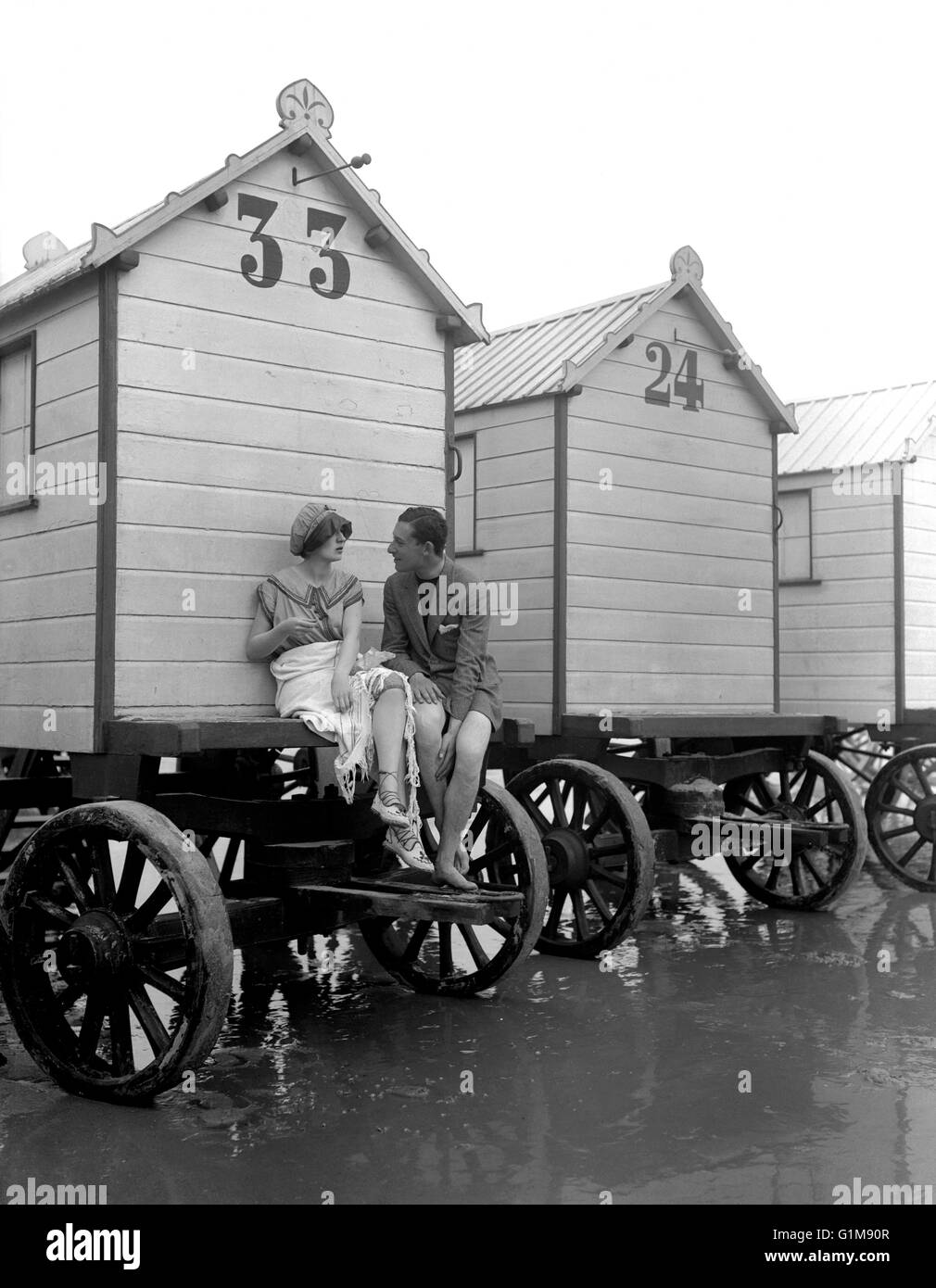 A couple chat while seated on a sea bathing hut at a British seaside resort. The huts were towed into the sea to spare the occupants the 'indignity' of making their way down the beach in their bathing costumes. ... Leisure and Tourism - The Seaside - Margate ... 01-08-1910 ... Margate ... UK ... Photo credit should read: PA/Unique Reference No. 1431736 ... Stock Photo
