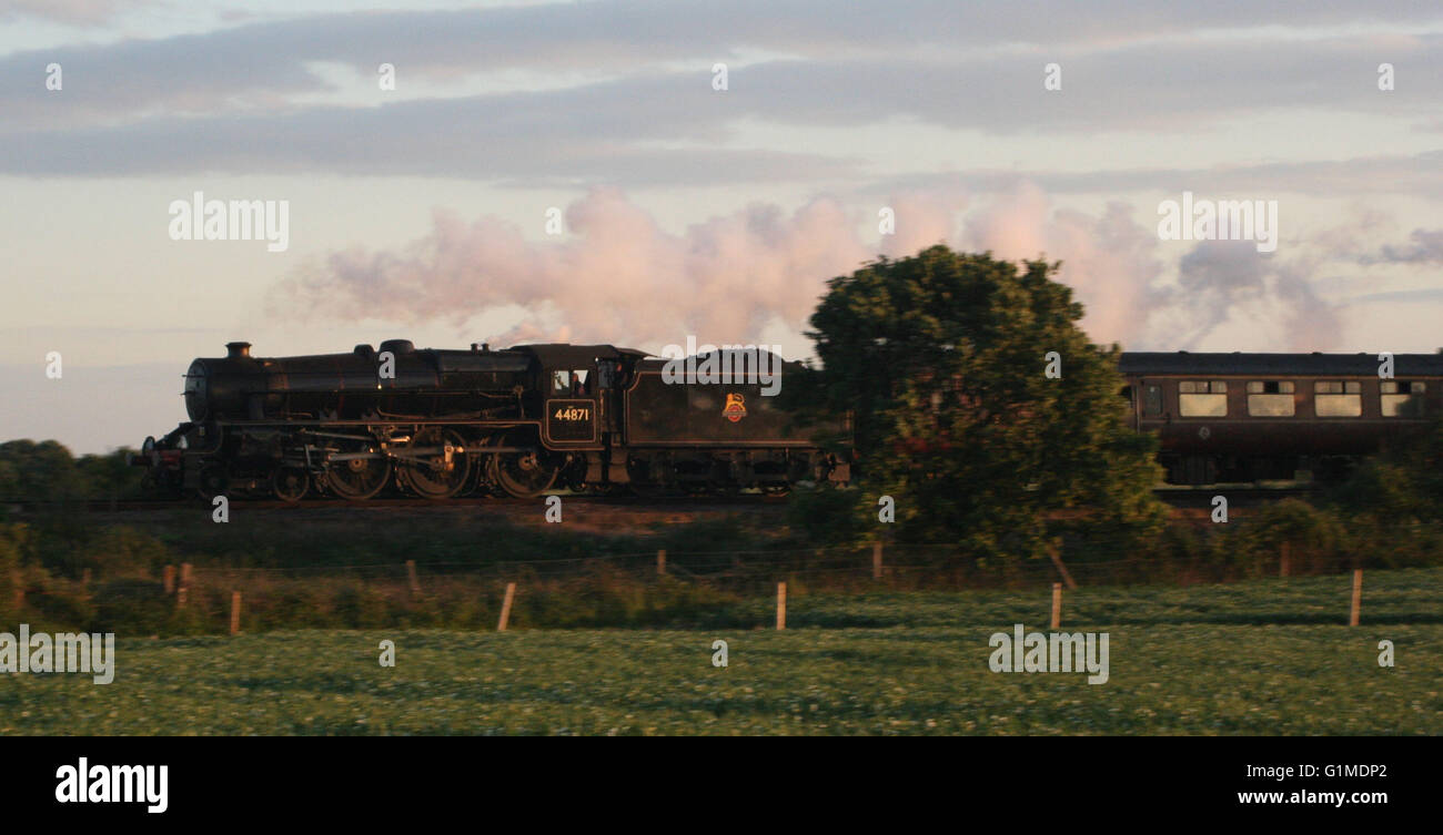 44871 catches the dying rays of the sun as it hurries down the grade to Barnham Stock Photo