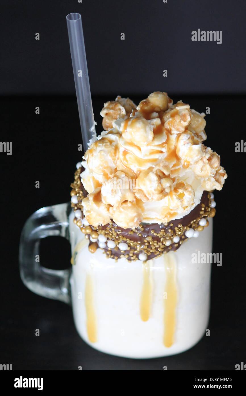 Caramel Milkshake With Whipped Cream & Caramel Popcorn, Dripping With Syrup Encrusted With A Chocolate Coated Rim & Sprinkles Stock Photo
