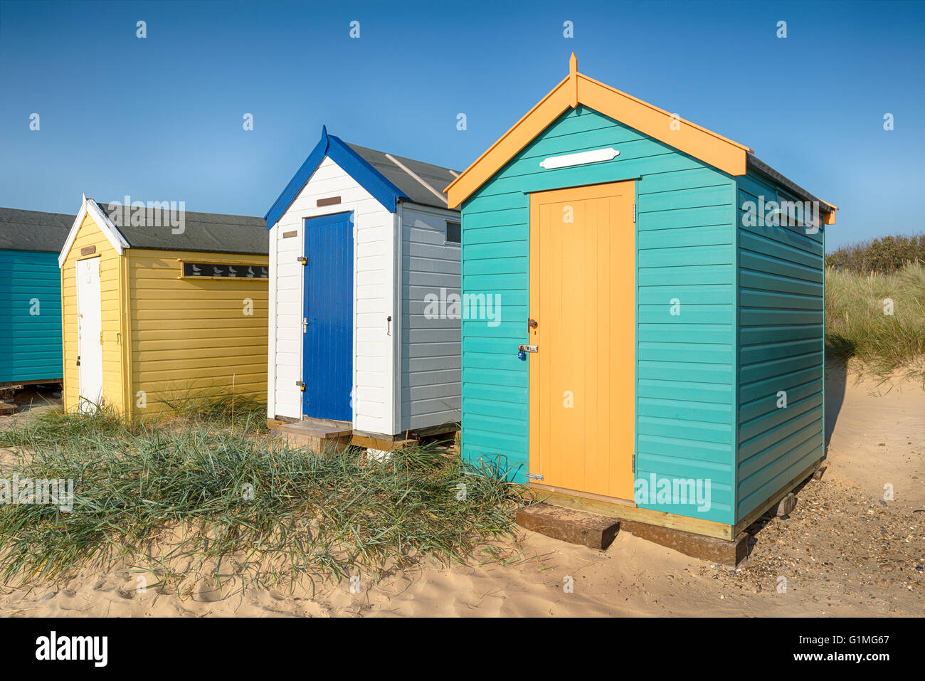 Colourful beach huts in sand dunes at Southwold in Suffolk Stock Photo