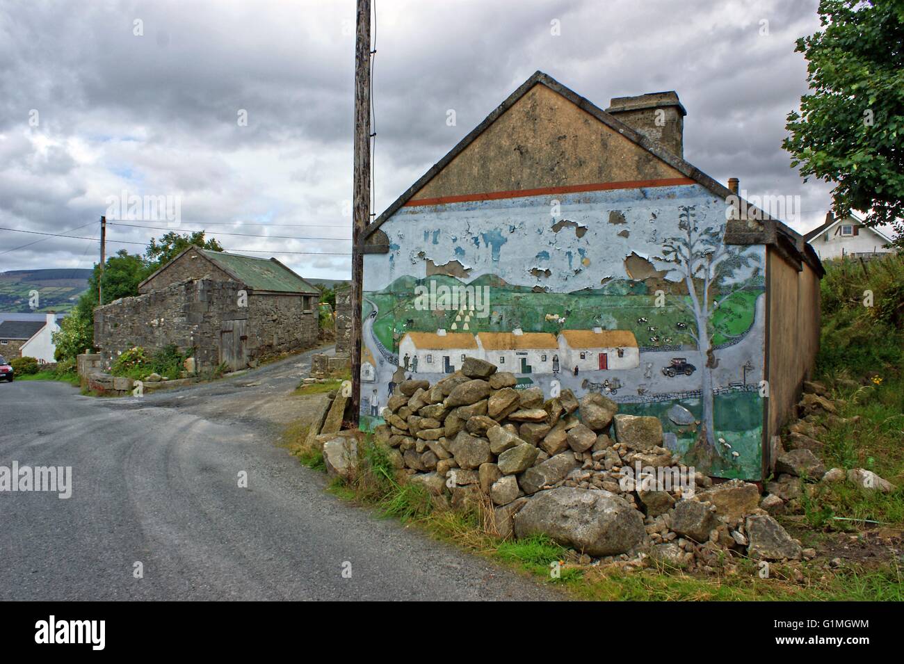 Old painting, Graffiti on a old stone cottage, in Ireland, showing village houses. In front rubble of stones, a  Irish village Stock Photo