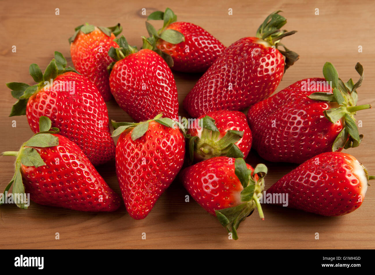 Ripe strawberries over wooden table background Stock Photo - Alamy