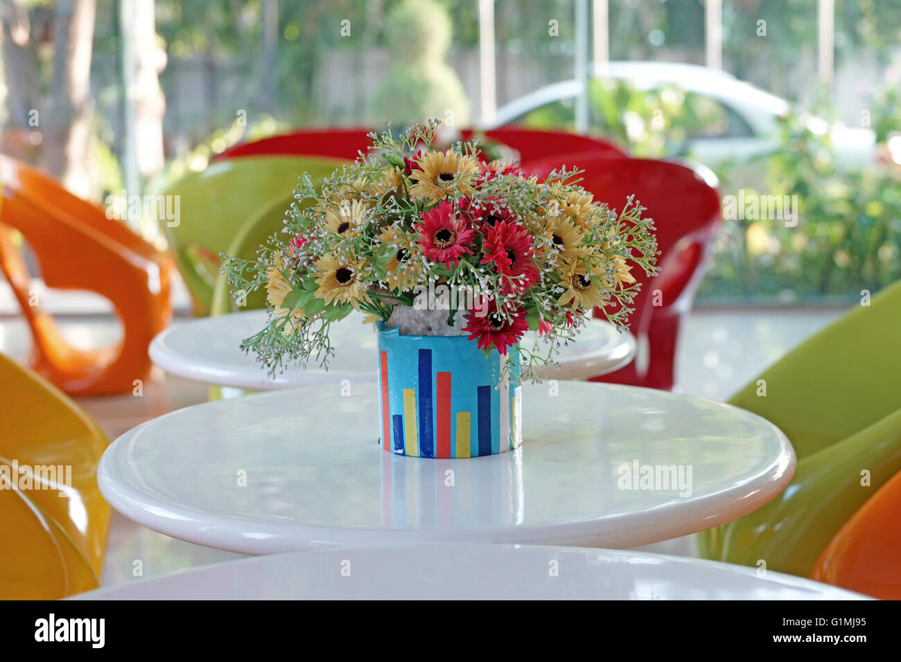 colorful artificial flower in flowerpot on the table Stock Photo