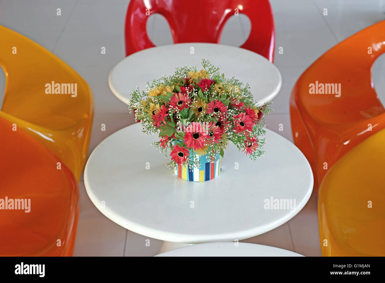 colorful artificial flower in flowerpot on the table Stock Photo