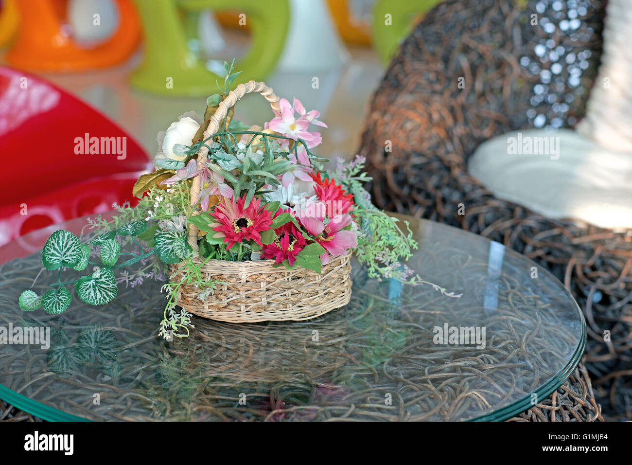 colorful artificial flower in basket on the table Stock Photo
