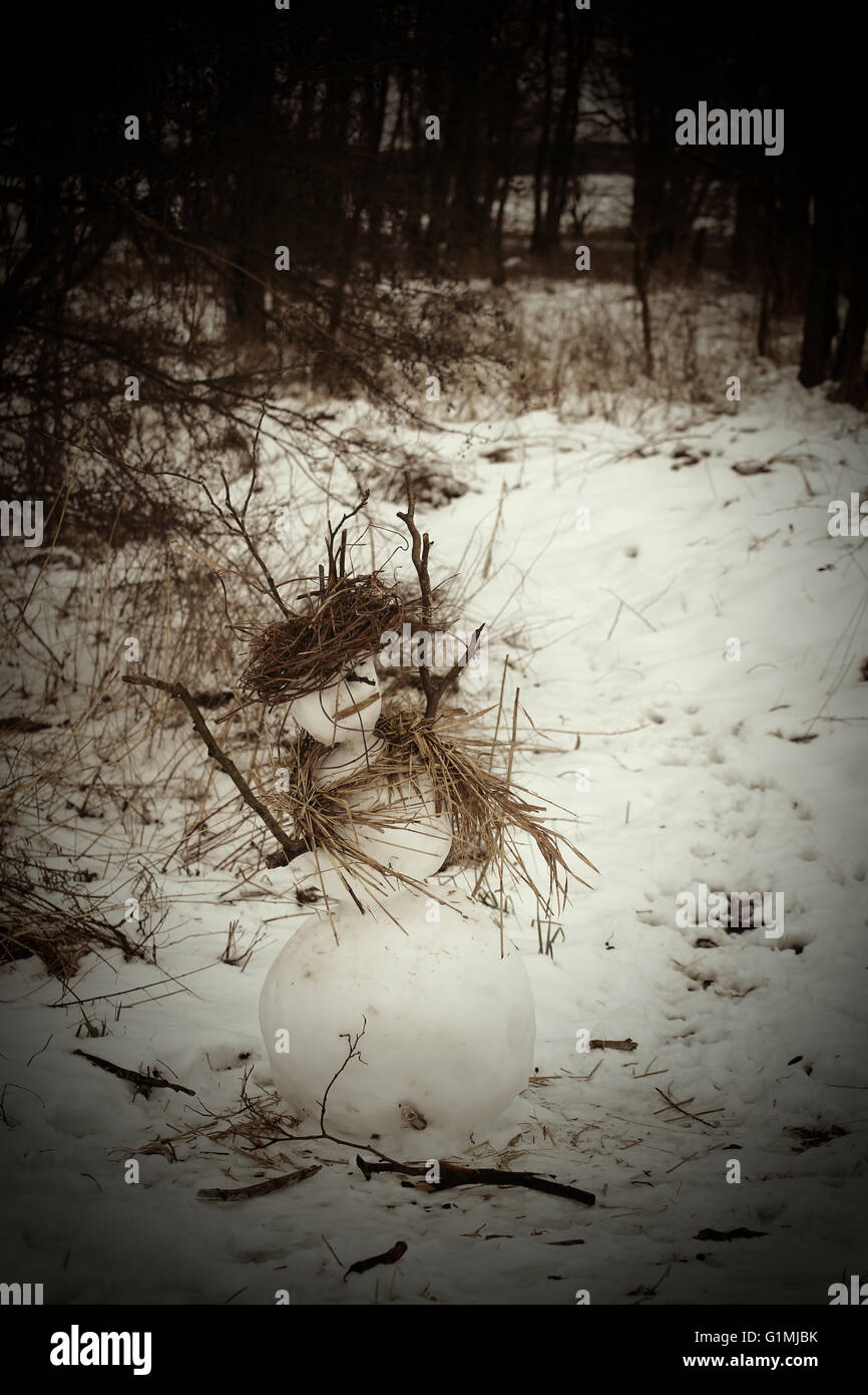 Sepia image of a rural snowman, made with sticks and reed. Stock Photo