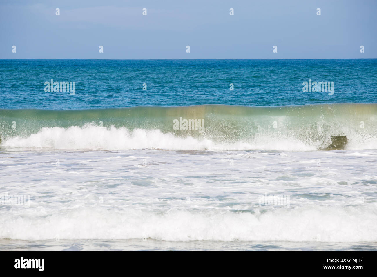 A wave crashes on a beach Stock Photo - Alamy
