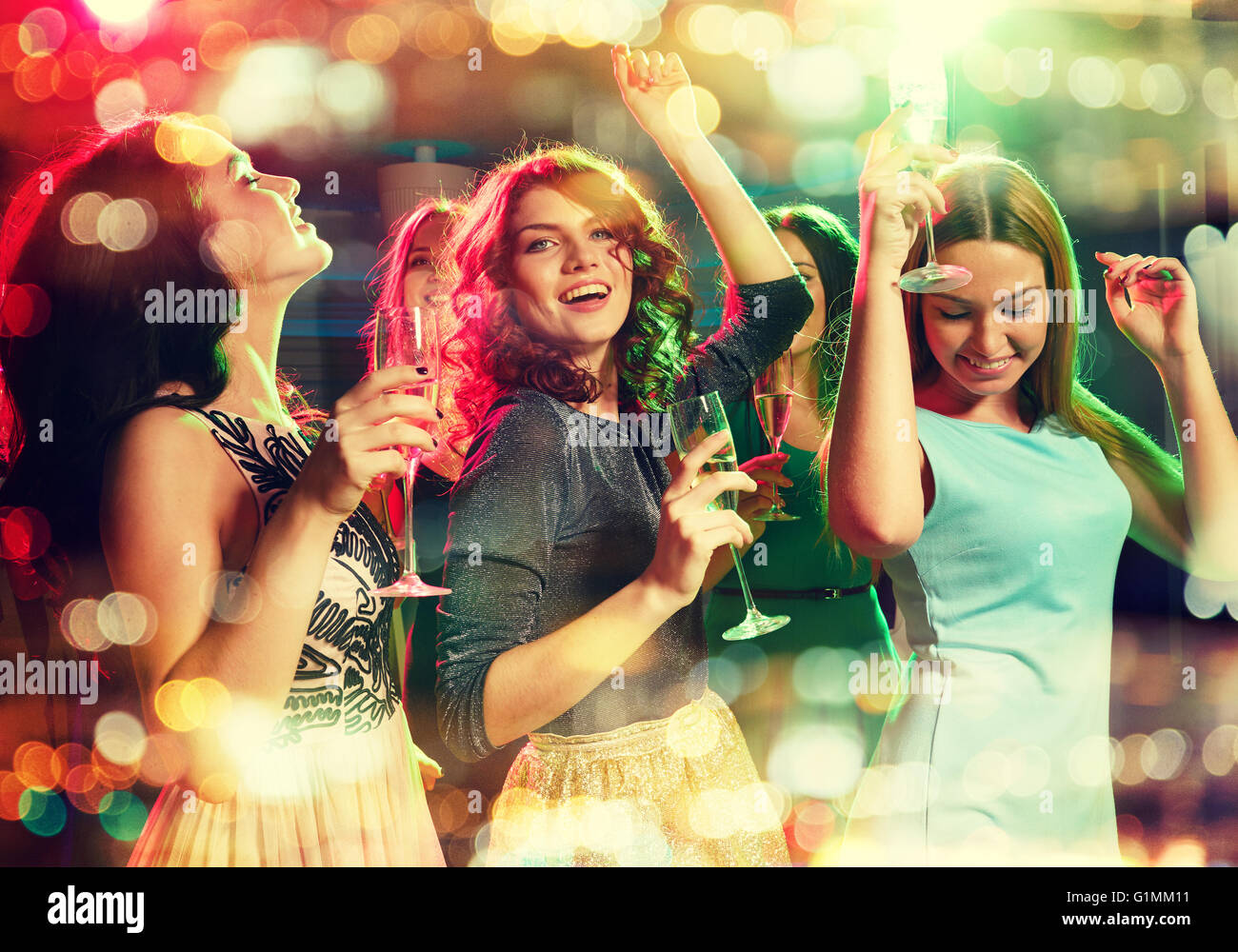 smiling friends with glasses of champagne in club Stock Photo