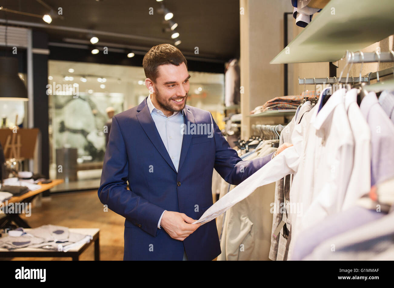happy young man choosing clothes in clothing store Stock Photo - Alamy