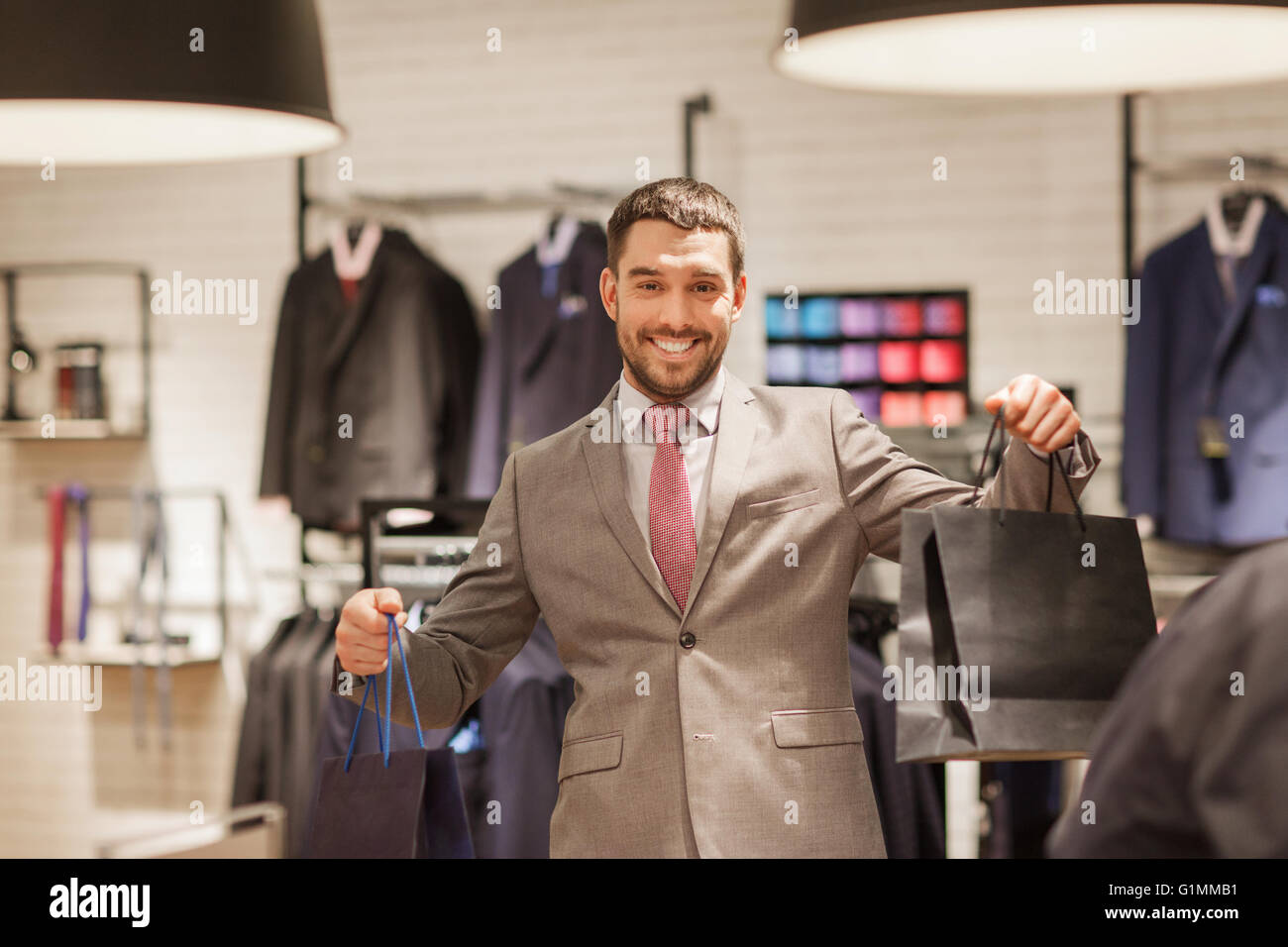 happy man with shopping bags at clothing store Stock Photo - Alamy