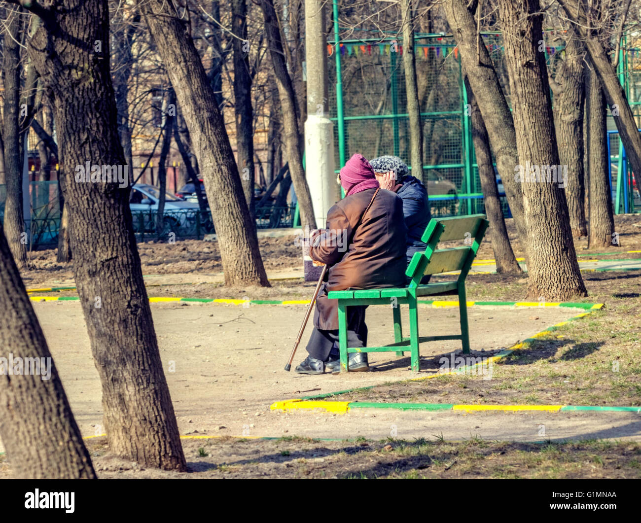 Two elderly women on bench in park on spring day Stock Photo