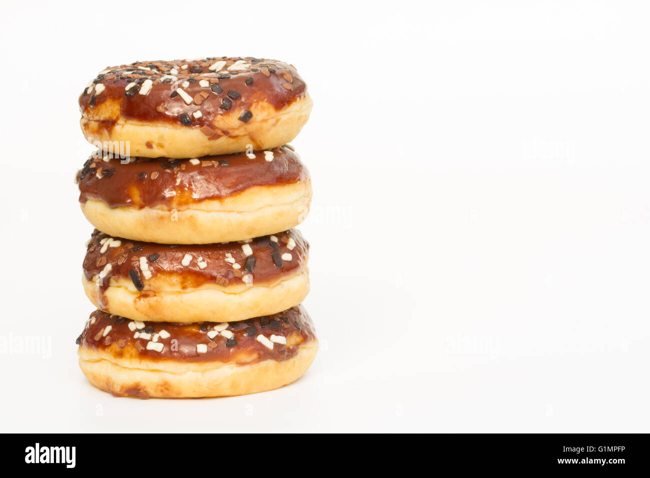 A stack of doughnuts with chocolate icing and sprinkles on an isolated ...
