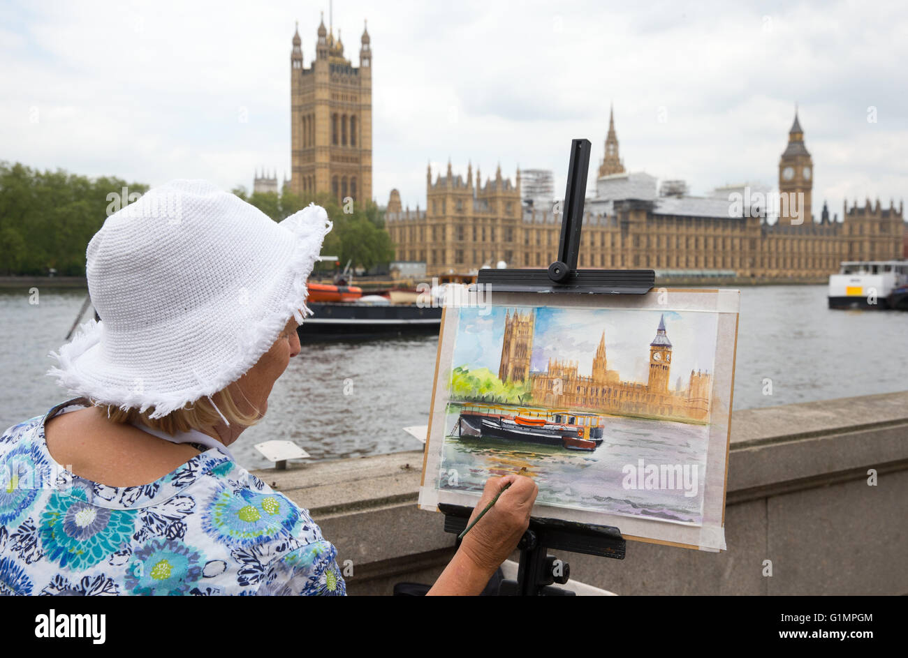 An artist paints the Houses of Parliament and Big Ben from across the river Thames Stock Photo