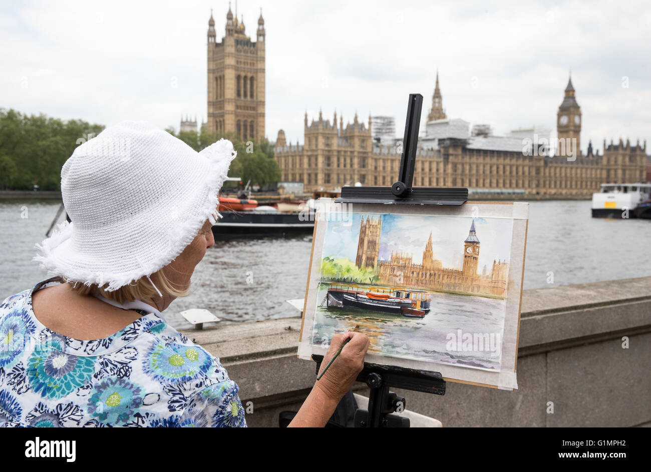An artist paints the Houses of Parliament and Big Ben from across the river Thames Stock Photo