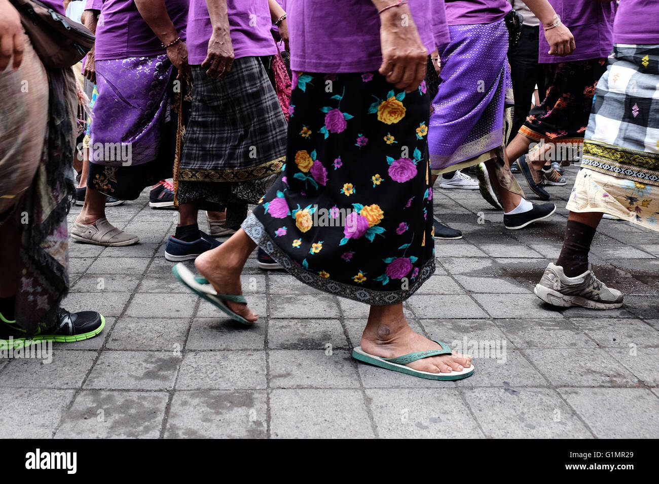Men walking in traditional clothes on the streets of Ubud, Bali Stock