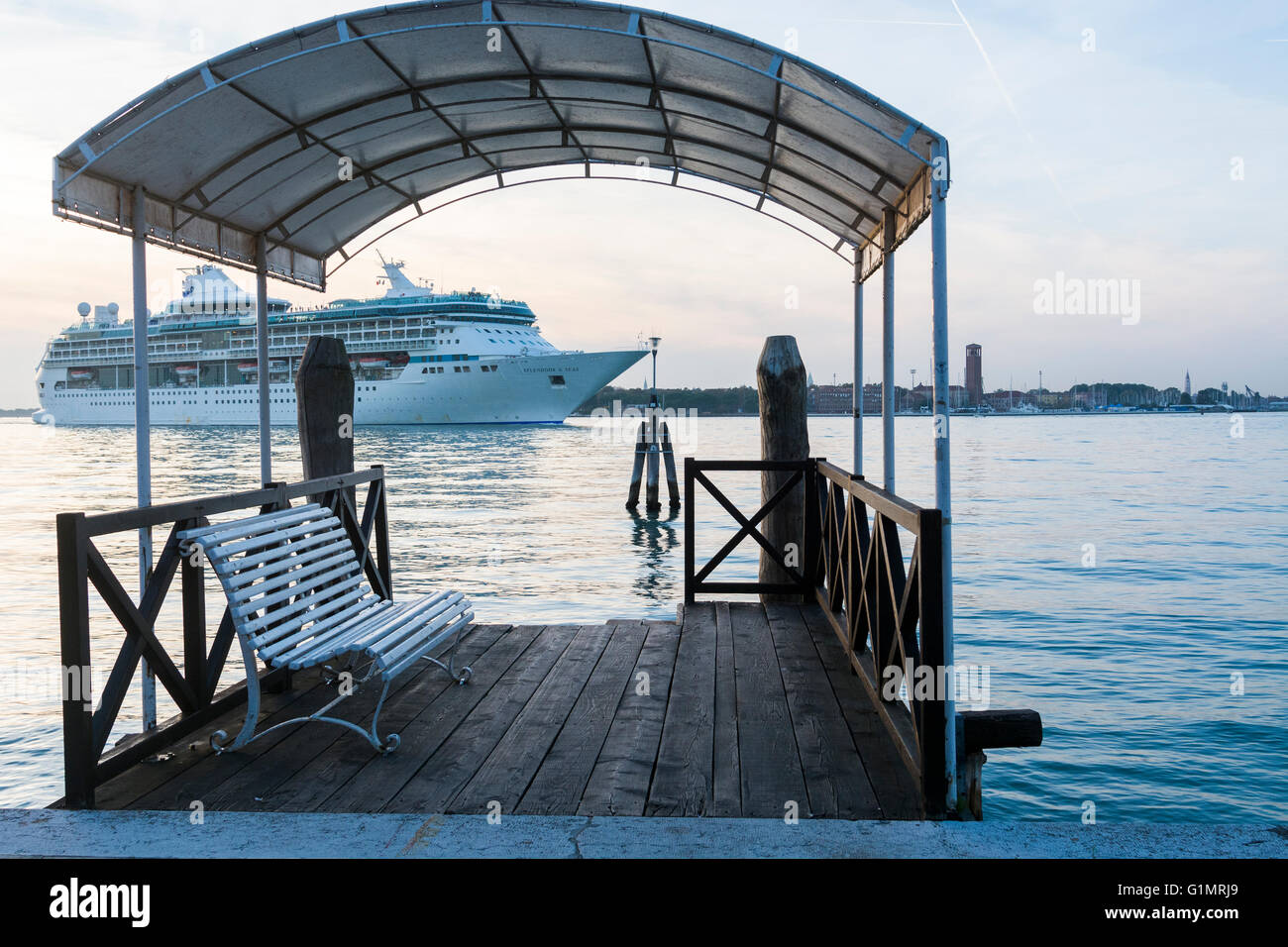 Cruise ship passing jetty on the Lido in the afternoon, Venice in the background Stock Photo