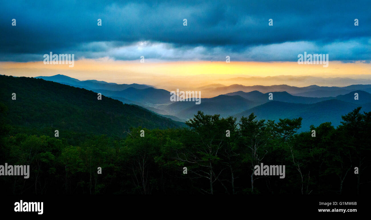 A panoramic view of the Blue Ridge Mountains with silhouetted foreground, vibrant sunset and a dramatic sky. Stock Photo