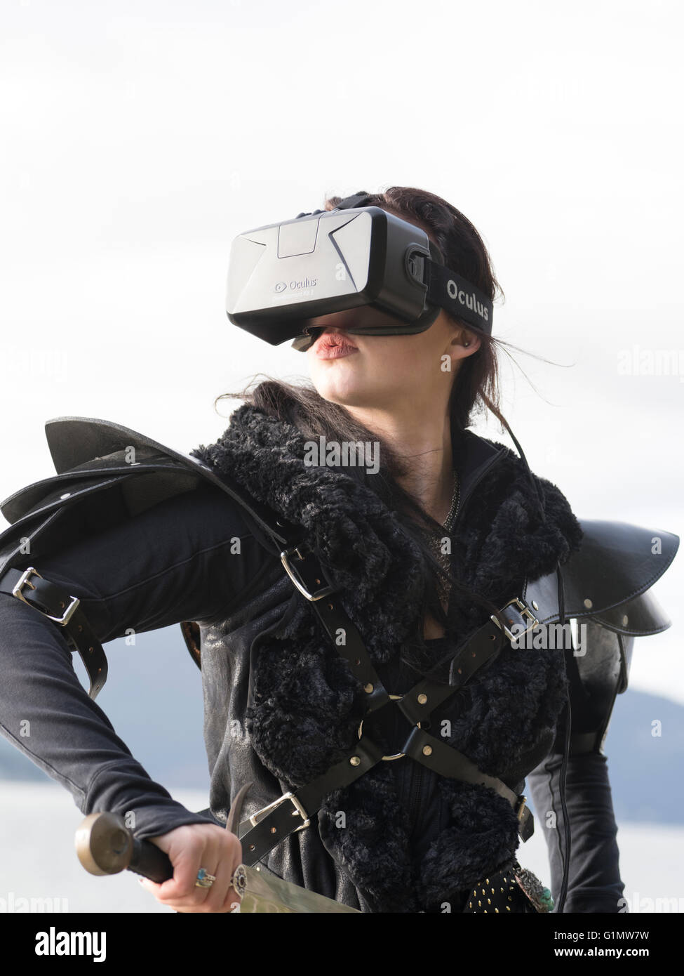 Conceptual picture of a young woman wearing costume and Oculus Rift Virtual Reality headset Stock Photo